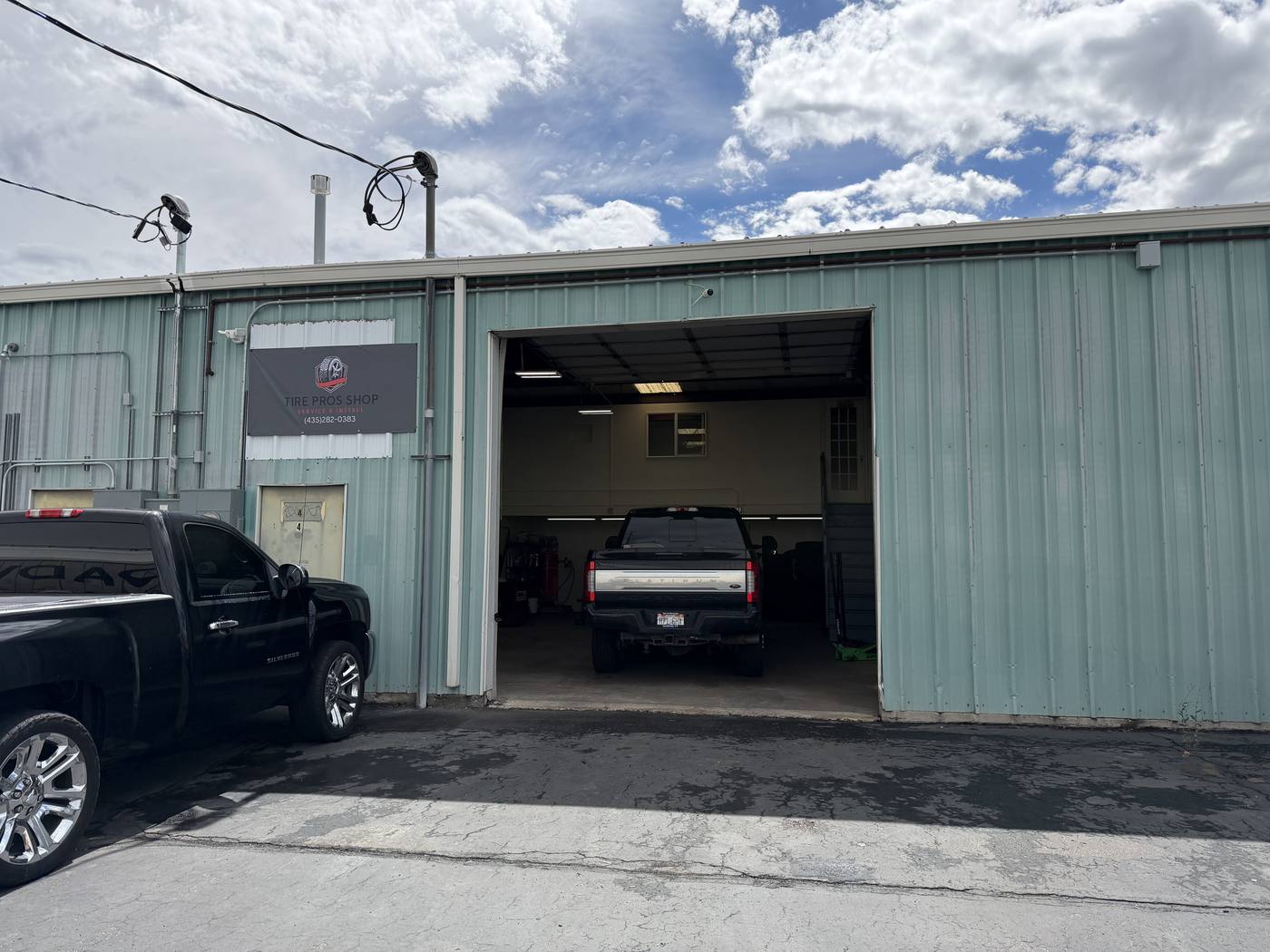 Tire Pros Shop storefront in Logan, Utah — unit 4, green metal building with the Tire Pros Shop banner above the bay door